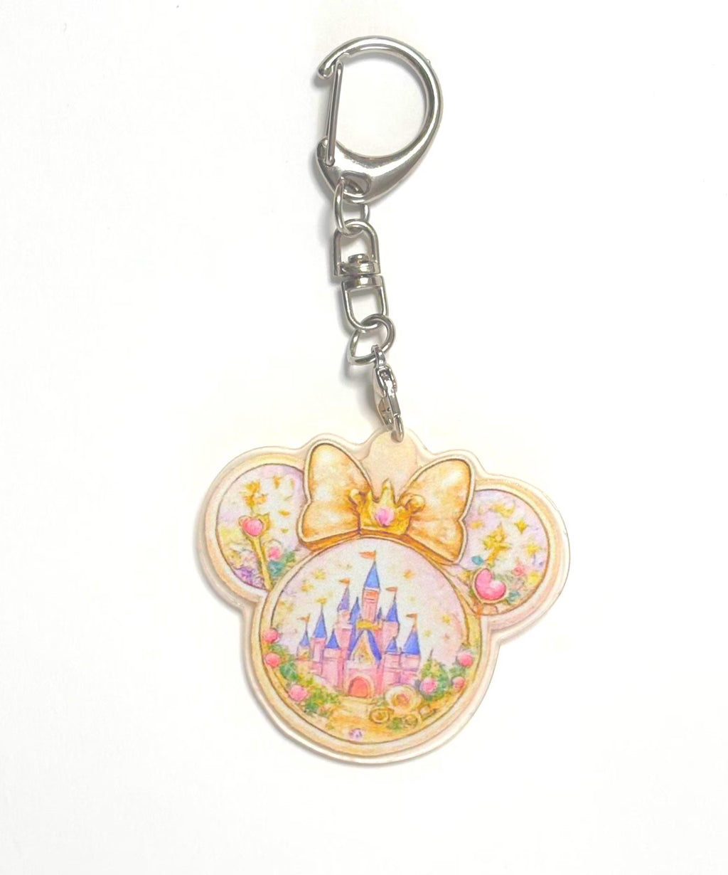 Golden Kingdom Pocket Charm featuring a resin mouse-ear charm with an enchanted castle, golden crown bow, floral accents, and silver lobster clasp.