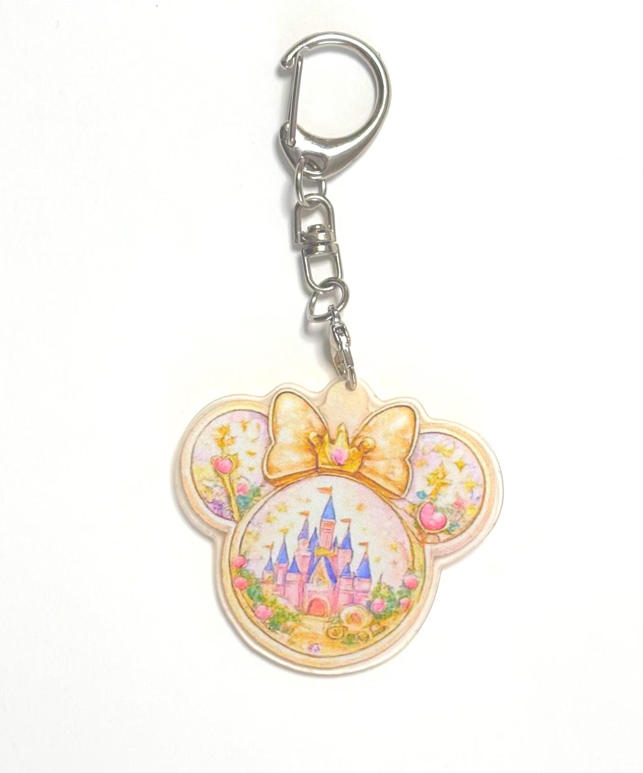 Golden Kingdom Pocket Charm featuring a resin mouse-ear charm with an enchanted castle, golden crown bow, floral accents, and silver lobster clasp.