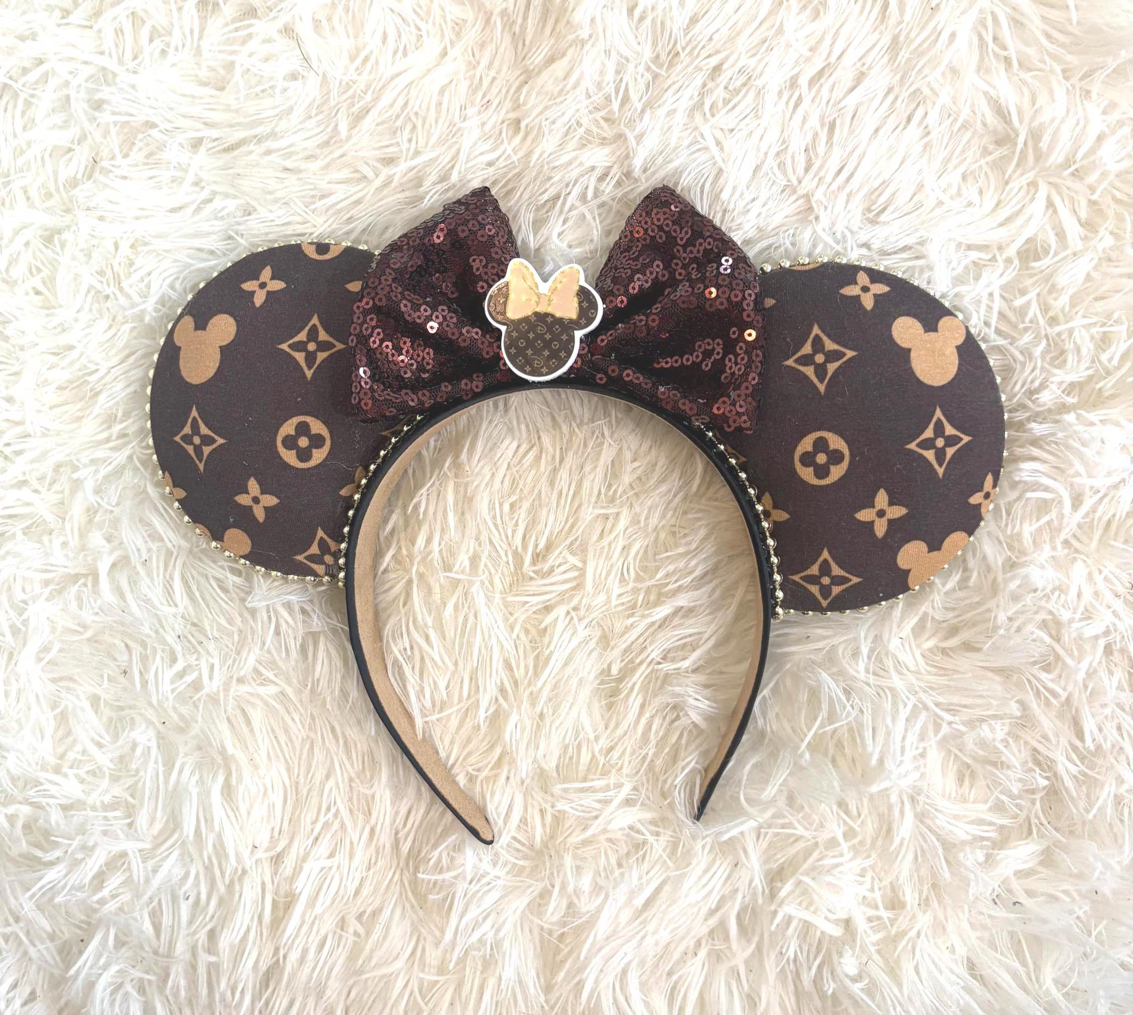 Handcrafted Heritage Luxe Boutique mouse ear headband featuring a rich brown designer-inspired print with subtle mouse silhouettes, an espresso sequin bow, pearl trim, decorative mouse silhouette centerpiece, and a lightweight comfort-fit headband.