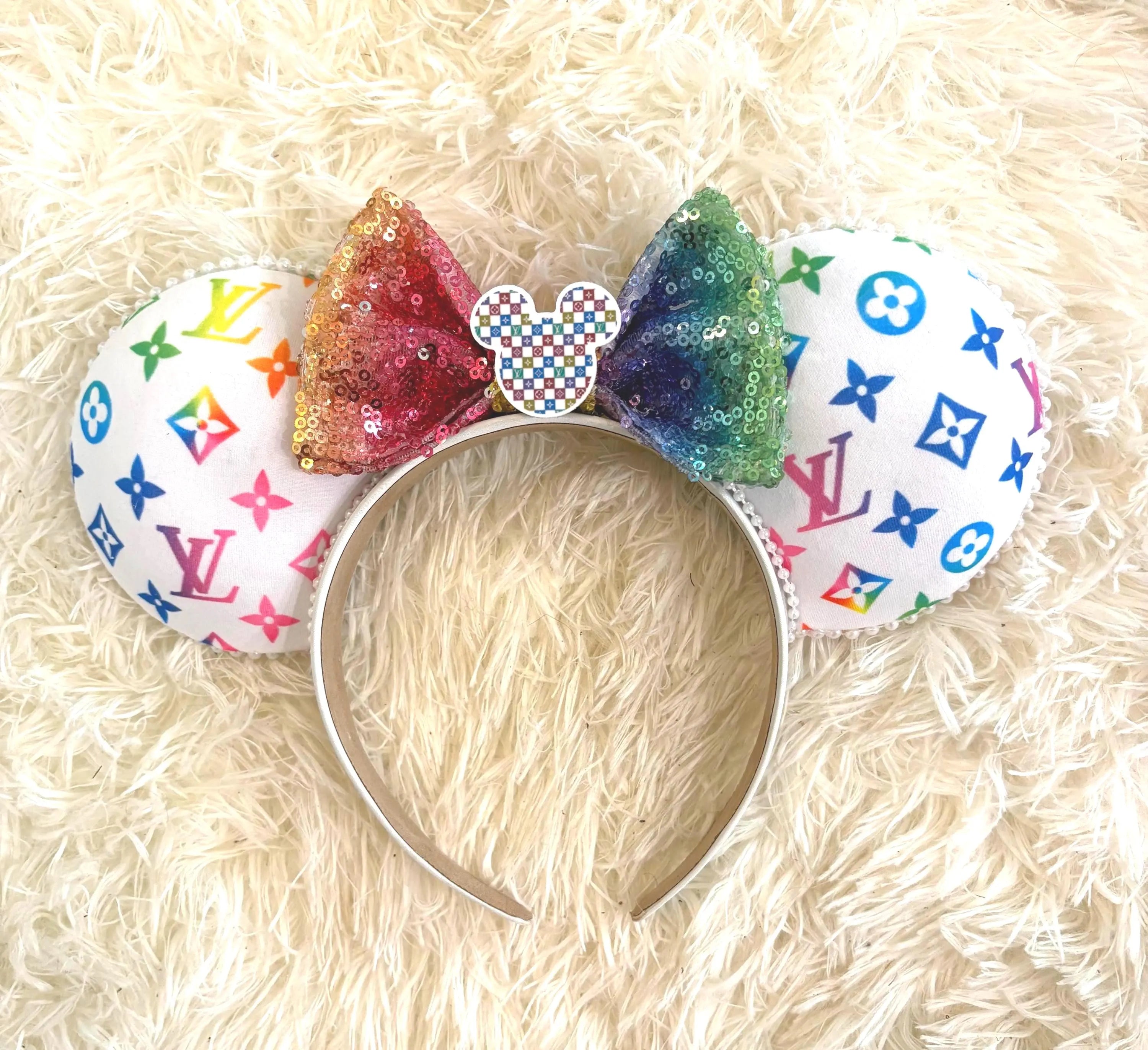 Handcrafted Luxe Spectrum boutique mouse ear headband with colorful designer-inspired pattern, rainbow sequin bow, decorative resin centerpiece, and lightweight comfort-fit headband.