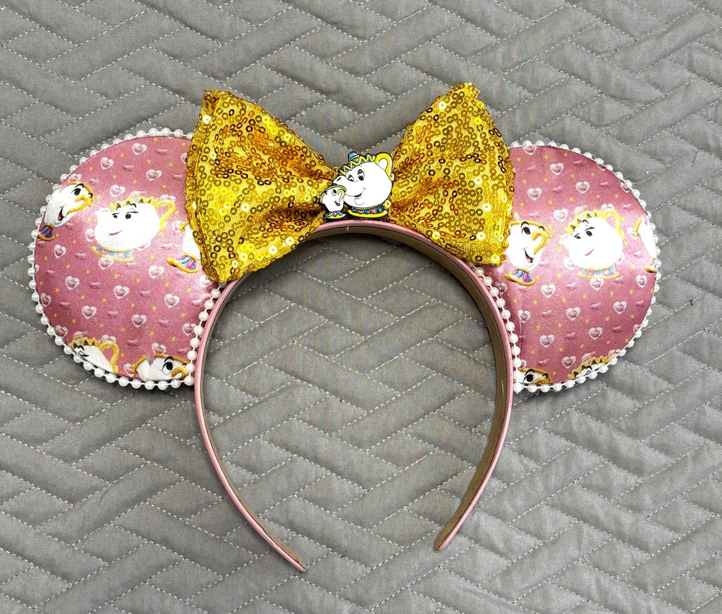 Tea & Tales Boutique Mouse Ear Headband featuring storybook tea-themed artwork, a sparkling gold sequined bow, and handcrafted boutique detailing.
