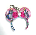 Castle Dreams Mini handcrafted mouse ear bag charm featuring a colorful fairytale castle-inspired print, satin pink bow with rose centerpiece, pearl trim, and coordinating design with the Castle Dreams headband.
