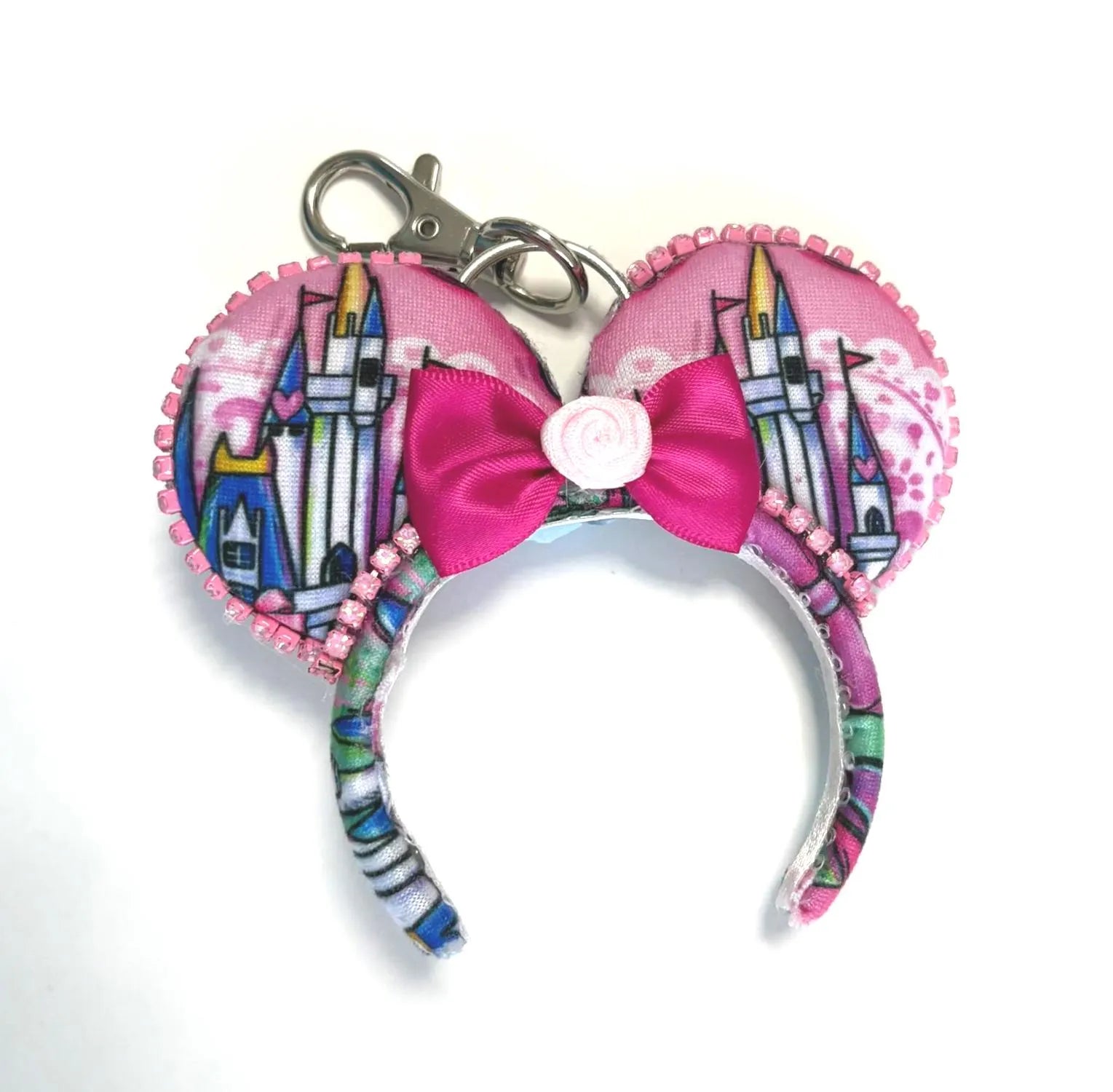 Castle Dreams Mini handcrafted mouse ear bag charm featuring a colorful fairytale castle-inspired print, satin pink bow with rose centerpiece, pearl trim, and coordinating design with the Castle Dreams headband.