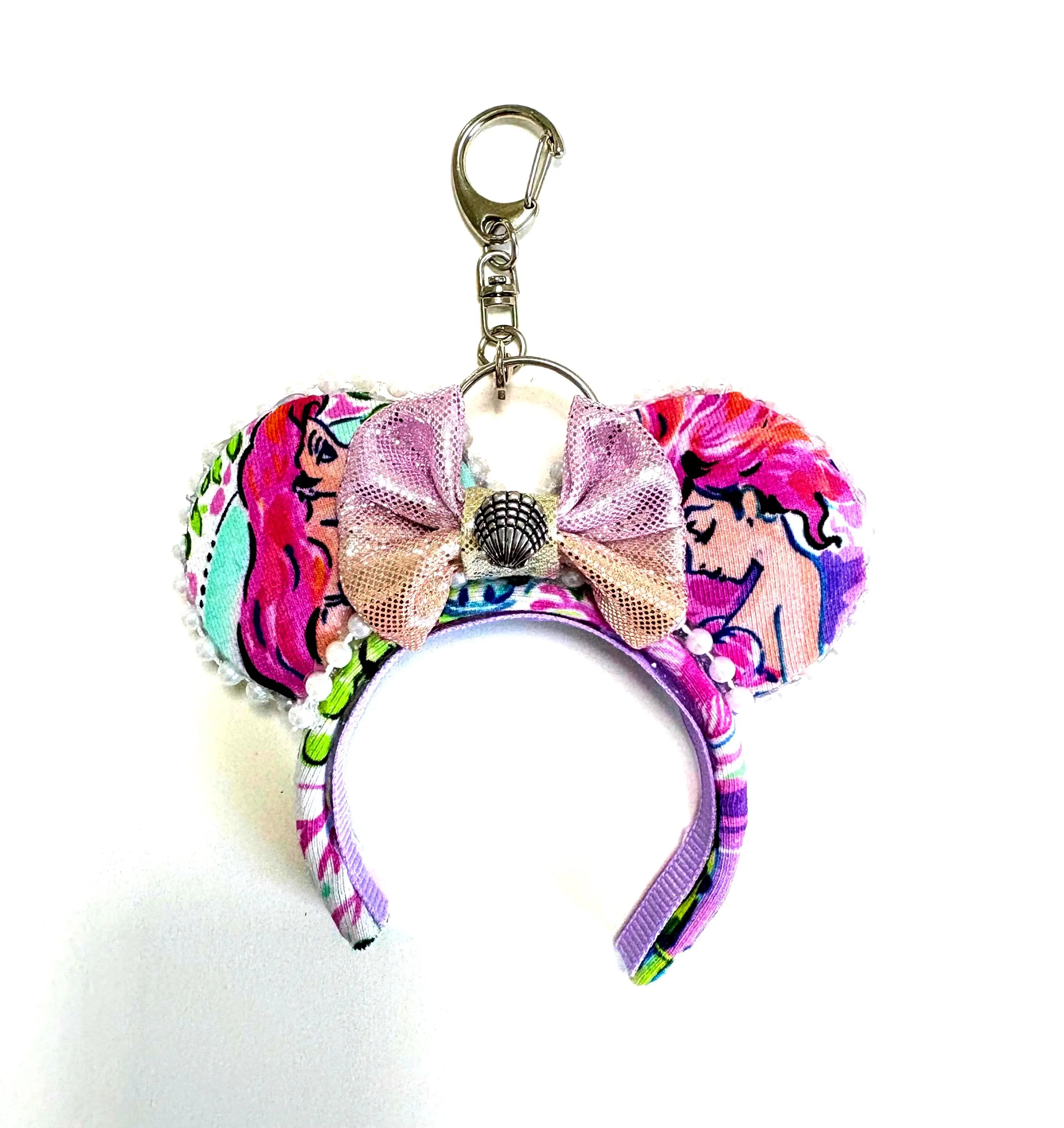 Handcrafted Mermaid Dreams mini ear keychain featuring ocean-inspired artwork, pastel satin bow with seashell accent, pearl trim, and silver clasp by Pixie Park Co.