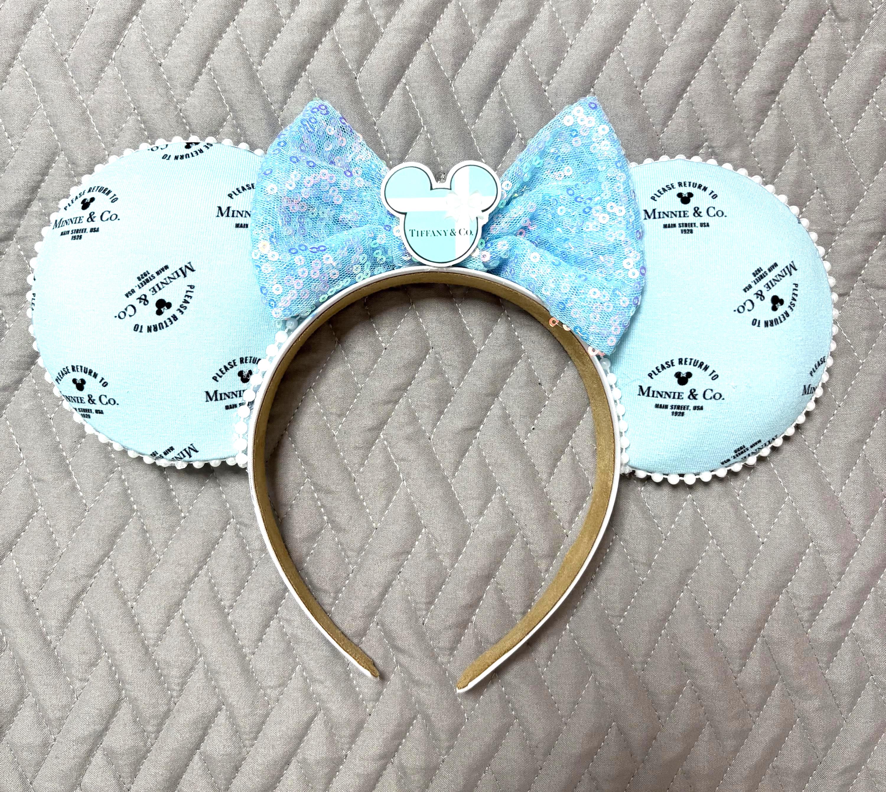 Handcrafted Blue Box Boutique mouse ear headband featuring designer-inspired robin's egg blue fabric, iridescent blue sequin bow, pearl trim, decorative mouse centerpiece, and lightweight comfort-fit headband.