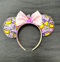 Imagination Journey Boutique Mouse Ear Headband from the Pixie Park Essentials Collection featuring whimsical purple dragon-inspired artwork, a soft pink bow, handcrafted lightweight construction, and comfortable all-day wear.