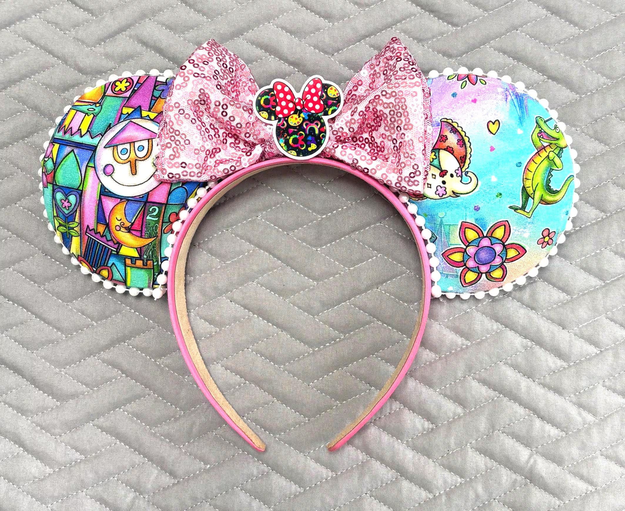 Whimsy in the Kingdom Boutique Mouse Ear Headband featuring colorful fantasy-inspired artwork, a pink sequined bow, and handcrafted boutique detailing.