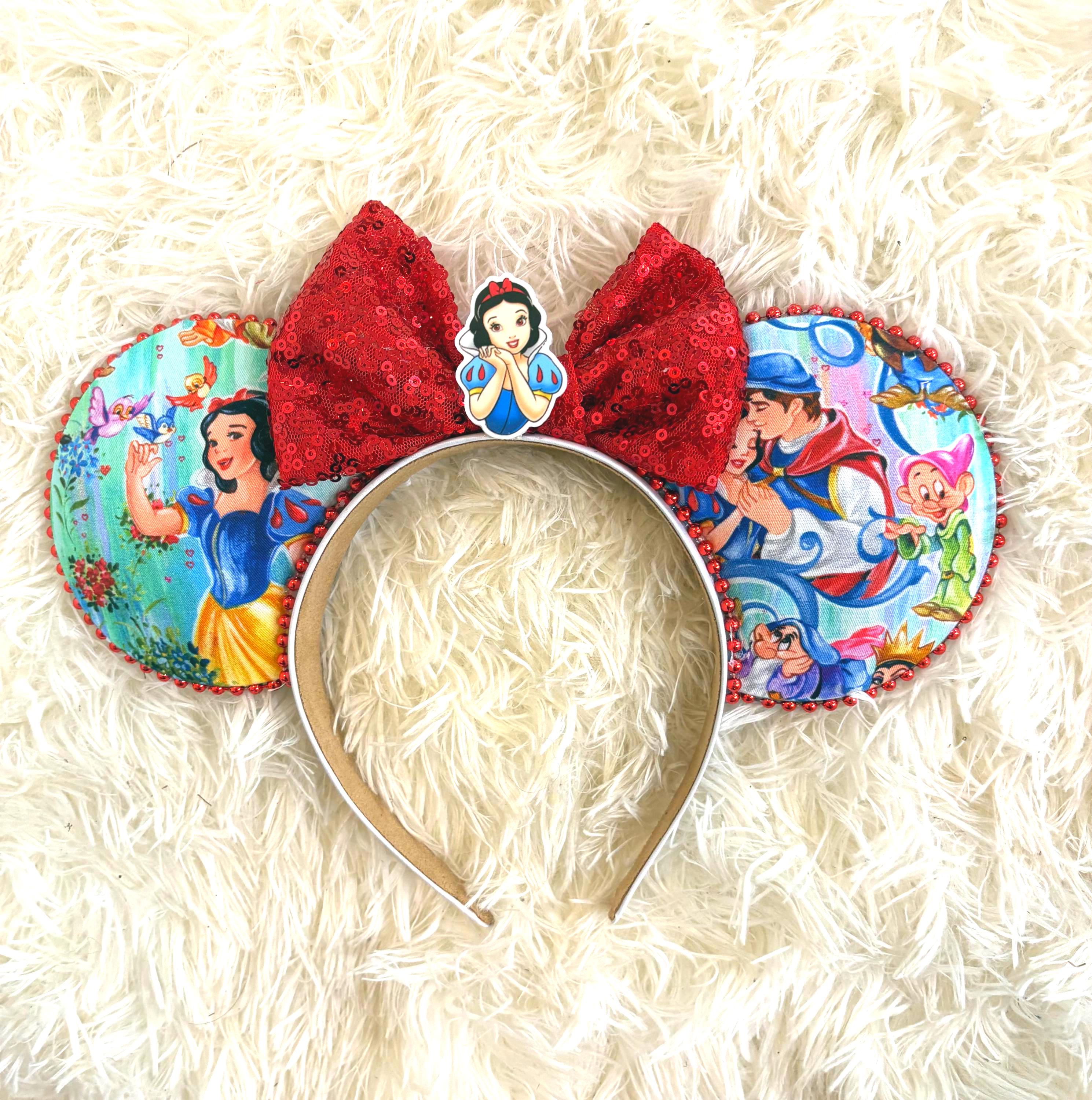 Magic Mirror Dreams Boutique Mouse Ear Headband featuring a storybook princess-inspired print, ruby red sequin bow, princess centerpiece, and handcrafted boutique styling by Pixie Park Co.