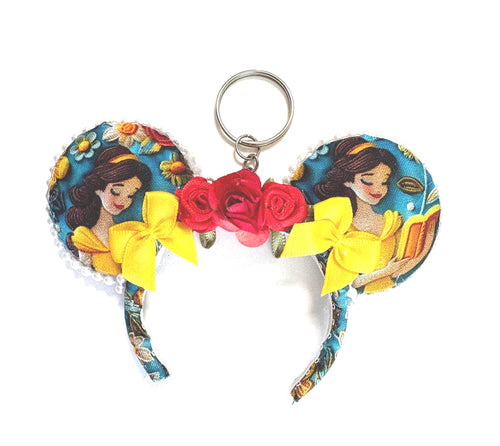 Handcrafted Bookworm Beauty mini ear keychain featuring fairytale-inspired artwork, yellow satin bows, red rose accents, pearl trim, and silver key ring by Pixie Park Co.