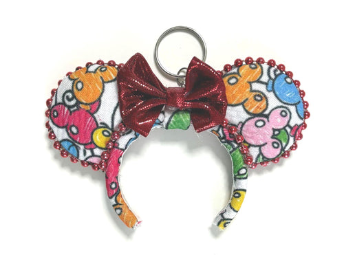 Handcrafted ColorPop Mini Ear Keychain & Bag Charm with colorful balloon-inspired graphics, burgundy glitter bow, decorative trim, and silver key ring.