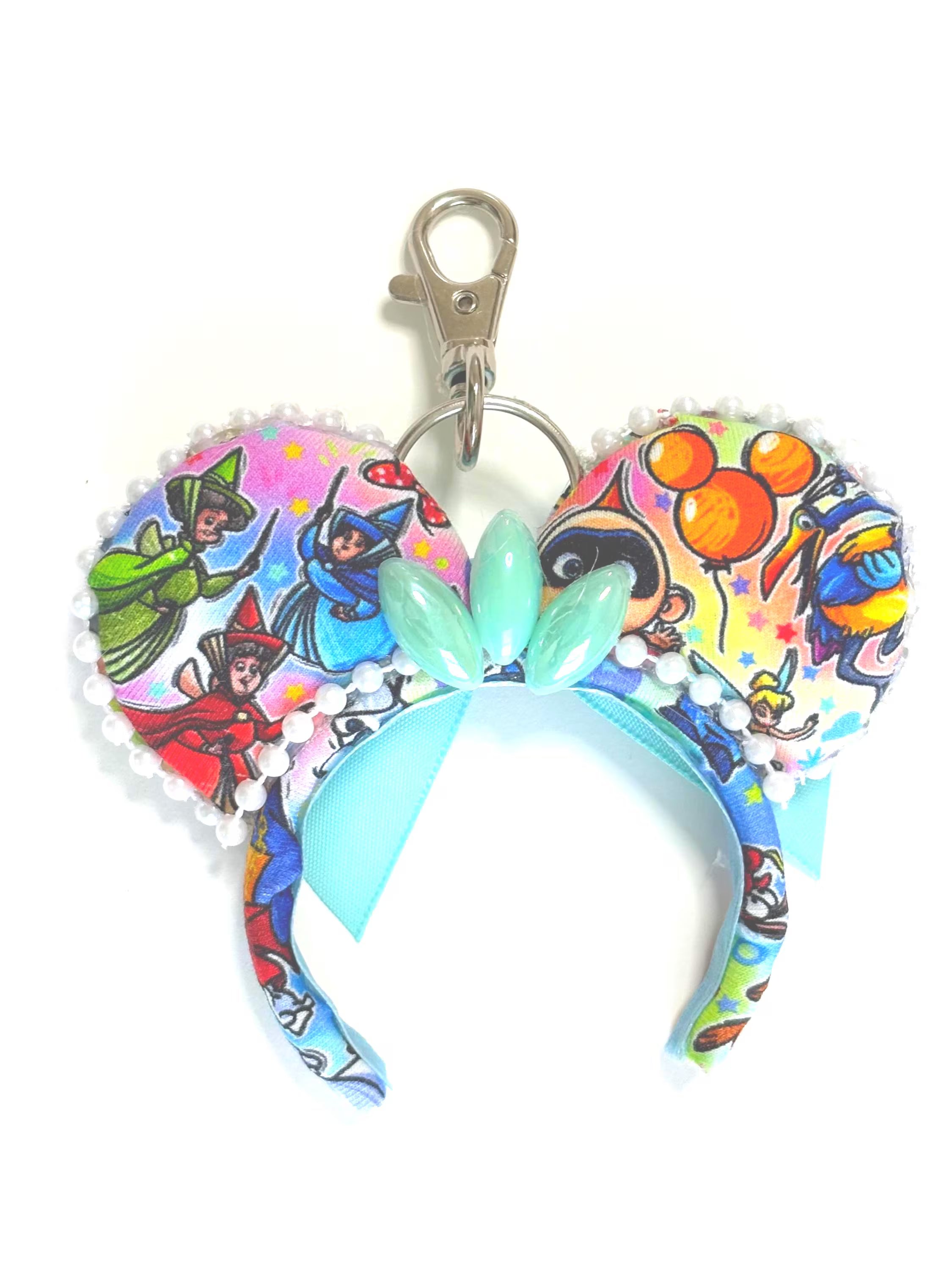 Park Celebration Mini Ear Keychain and Bag Charm featuring colorful park-inspired artwork, mint ribbon bow, pearl trim, and handcrafted boutique styling by Pixie Park Co.