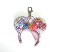 Palace Dreams Mini handcrafted mouse ear bag charm featuring a fairytale-inspired castle, carriage, glass slipper print, floral centerpiece, satin ribbon accents, and pearl trim.