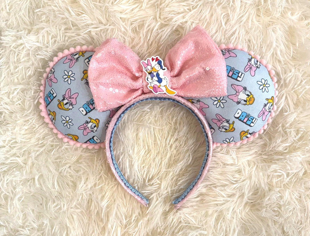 Daisy Days Boutique Mouse Ear Headband featuring pastel daisy-inspired artwork, a sparkling pink sequined bow, and handcrafted boutique detailing.