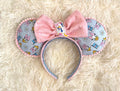 Daisy Days Boutique Mouse Ear Headband featuring pastel daisy-inspired artwork, a sparkling pink sequined bow, and handcrafted boutique detailing.