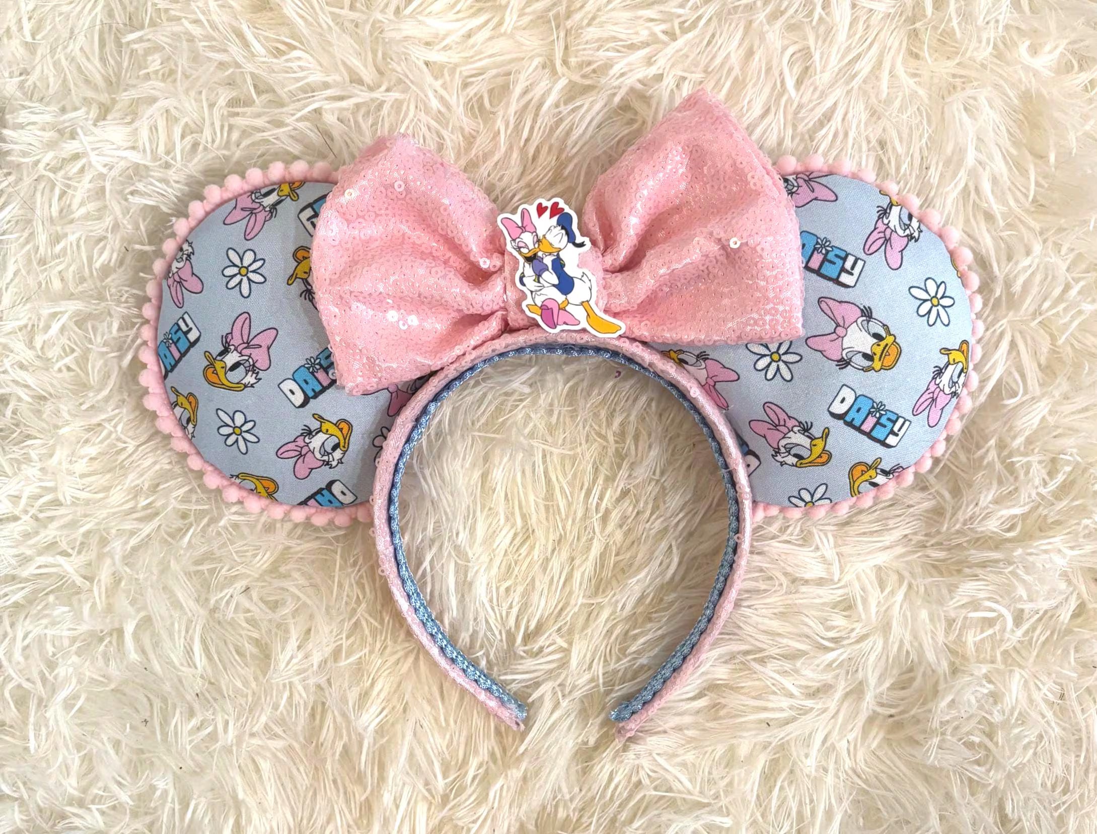 Daisy Days Boutique Mouse Ear Headband featuring pastel daisy-inspired artwork, a sparkling pink sequined bow, and handcrafted boutique detailing.