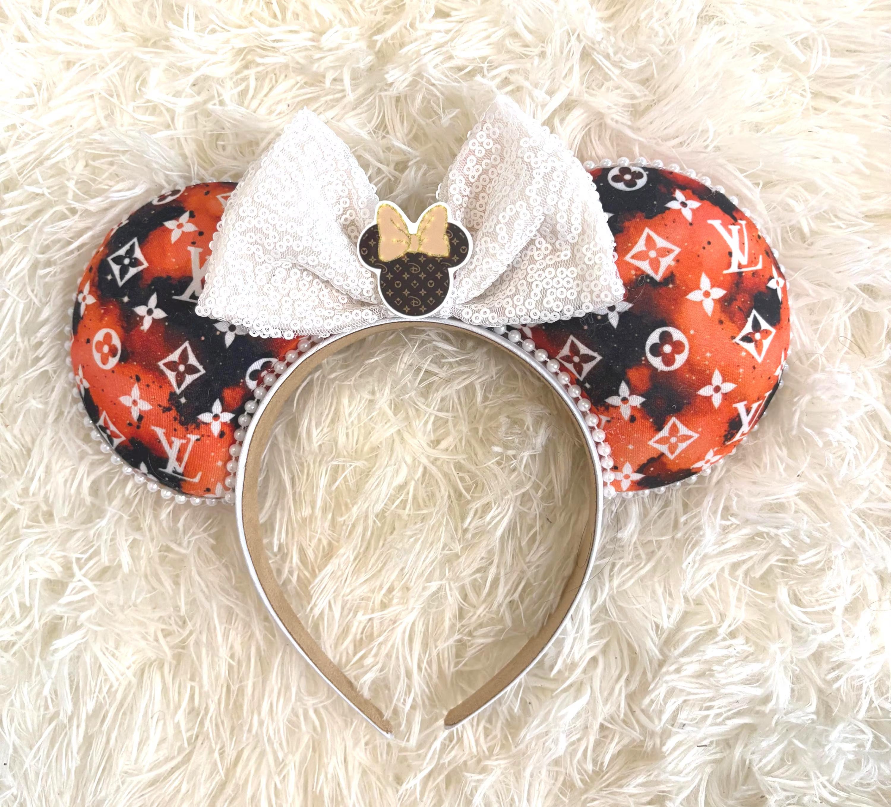 Handcrafted Ember Glow boutique mouse ear headband featuring designer-inspired orange, black, and white fabric, white sequin bow, pearl trim, decorative resin mouse silhouette centerpiece, and lightweight comfort-fit headband.