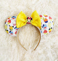 Sweet Treats Boutique Mouse Ear Headband from the Pixie Park Essentials Collection featuring colorful dessert-inspired artwork, a bright yellow sequin bow, decorative centerpiece, and handcrafted lightweight comfort-fit design.
