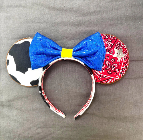 Country Western Boutique Mouse Ear Headband from the Pixie Park Essentials Collection featuring western-inspired cow print and bandana patterns, a vibrant blue bow, decorative western accent, and handcrafted lightweight comfort-fit design.