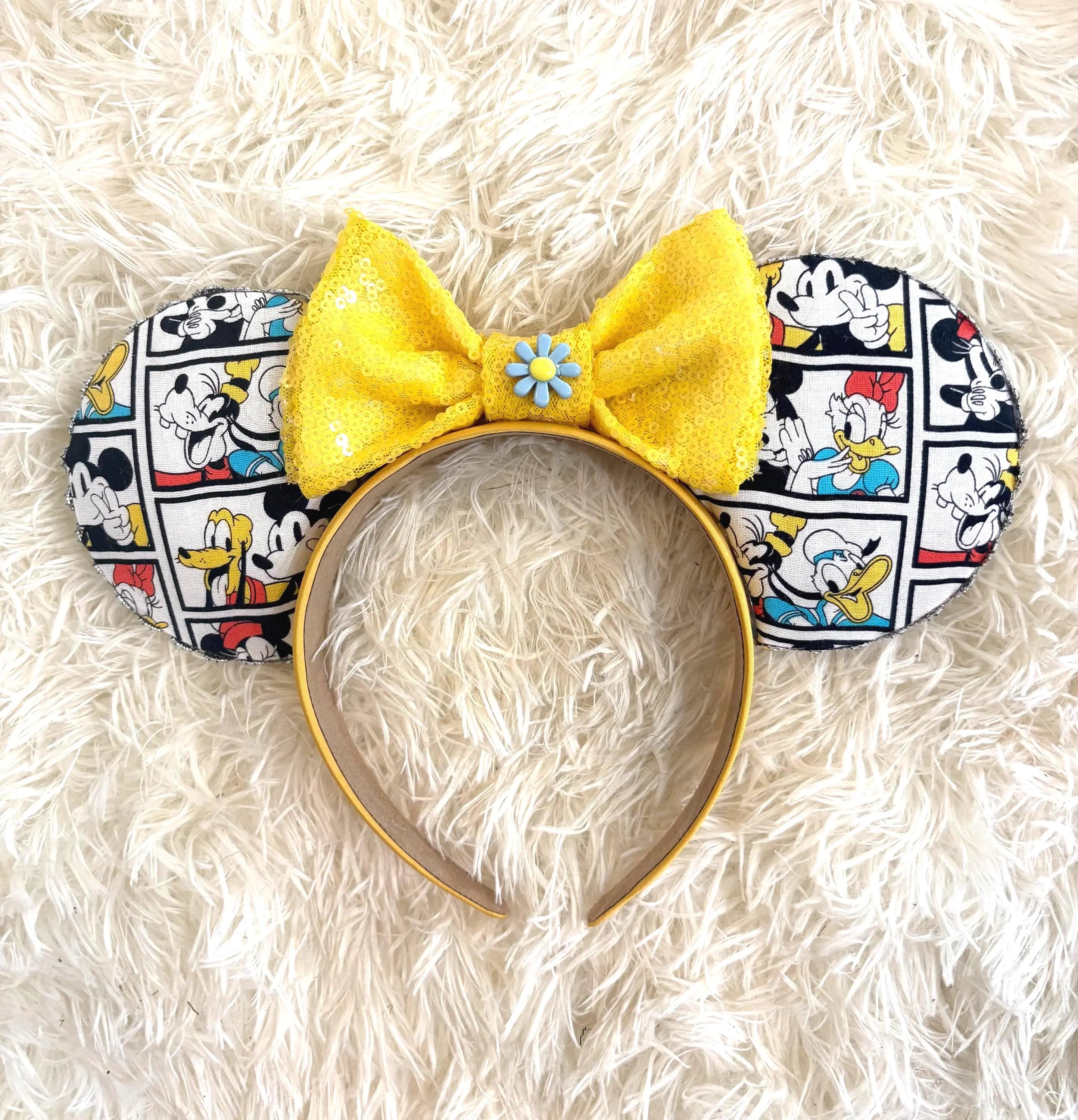 Vintage Toon Friends boutique mouse ear headband featuring a comic-inspired character print, sunshine yellow sequin bow, and blue daisy centerpiece.