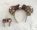 Handcrafted Heritage Luxe Pixie Pair featuring a matching mouse ear headband and coordinating Mini Magic Charm with a heritage-inspired luxury pattern, rich chocolate and gold tones, espresso sequined bow, decorative beaded trim, and elegant boutique styling.
