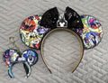 Handcrafted Enchanted Villains Pixie Pair featuring a villain-inspired mouse ear headband and coordinating Mini Magic Charm with colorful magical artwork, black sequin bow, decorative black beaded trim, and handcrafted boutique styling.