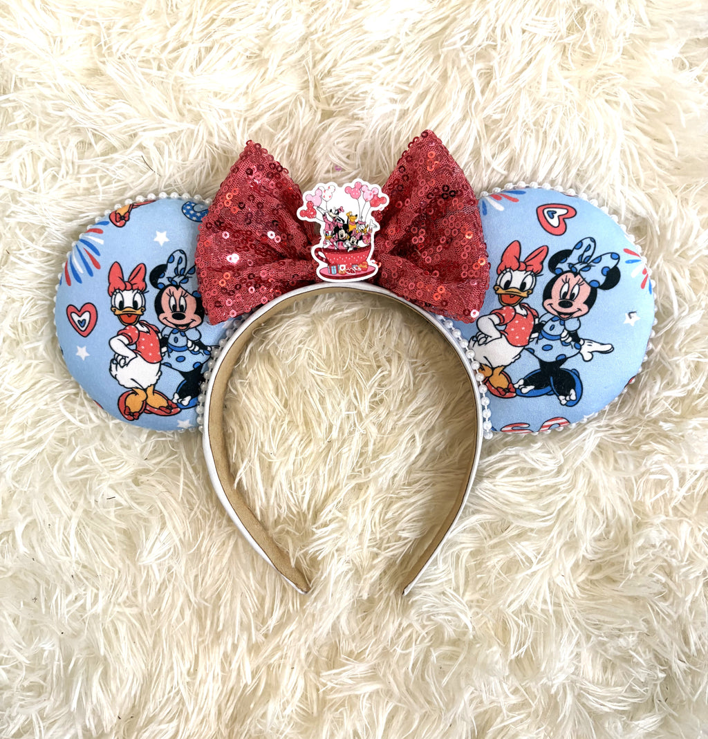 Handcrafted friendship-inspired mouse ear headband featuring two classic best friends on pastel blue fabric with a sparkling red sequin bow and boutique handcrafted styling.