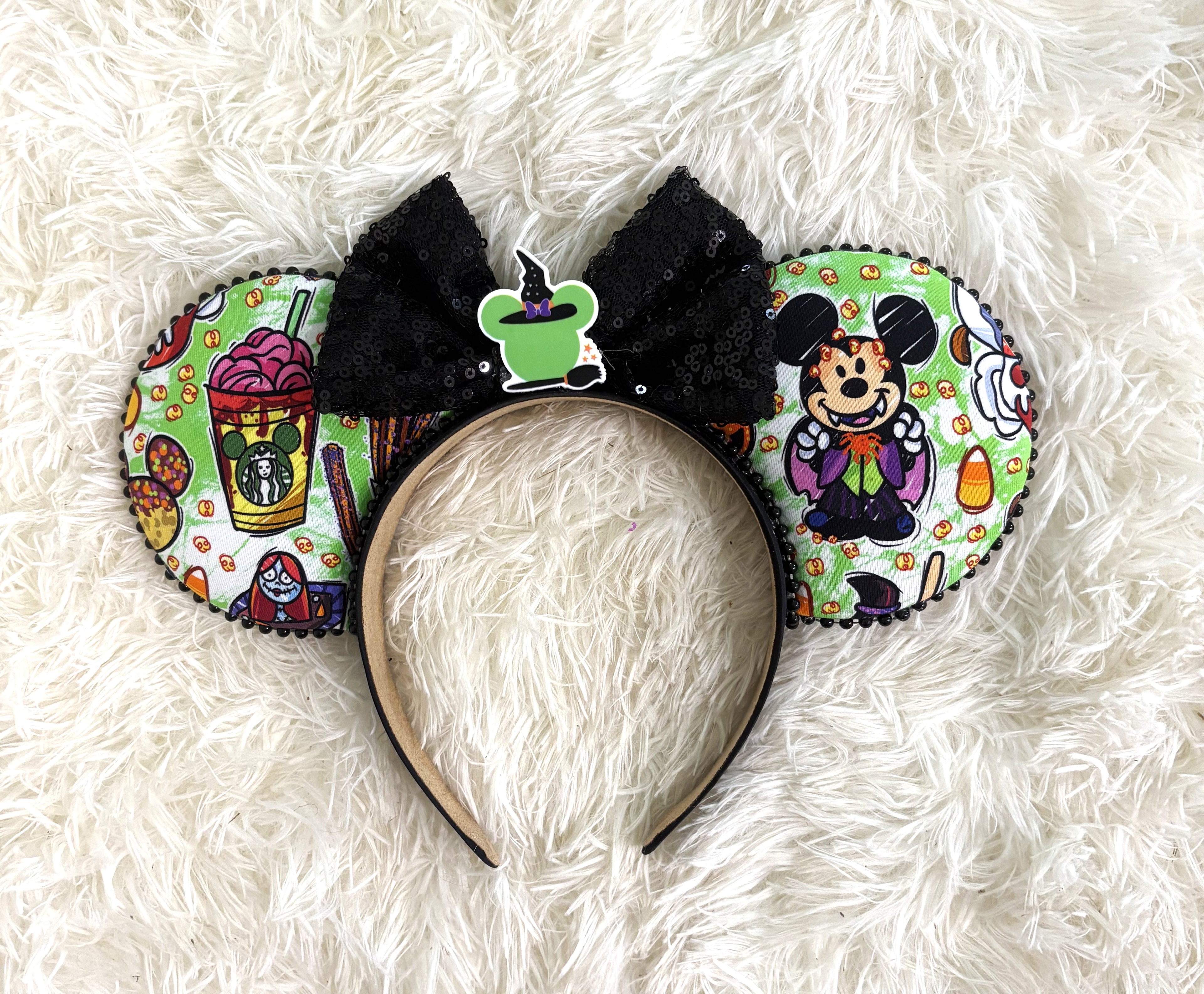 Handcrafted Halloween mouse ear headband featuring playful vampire-inspired artwork, festive treats, candy corn accents, and a sparkling black sequin bow.