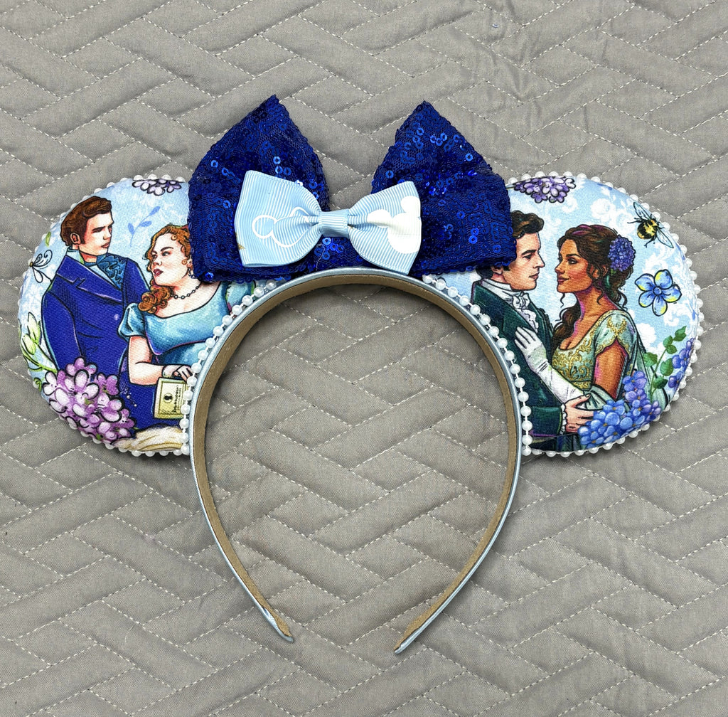 Handcrafted Bluebell Court Signature mouse ear headband featuring Regency-inspired blue floral artwork, a royal blue sequined bow, pearl trim, and a boutique-style headband by Pixie Park Company.