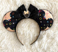 Pixie Park Company Metropolitan Luxe handcrafted mouse ear headband featuring black and neutral fashion-inspired geometric artwork, a shimmering black sequin boutique bow, decorative black beaded trim, and boutique styling, photographed against a textured white background.
