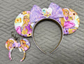 Pixie Park Company Golden Dreams Pixie Pair featuring a coordinated Signature mouse ear headband and matching Mini Magic Charm with elegant golden-inspired artwork, a coordinating boutique bow, decorative beaded trim, and handcrafted boutique styling.