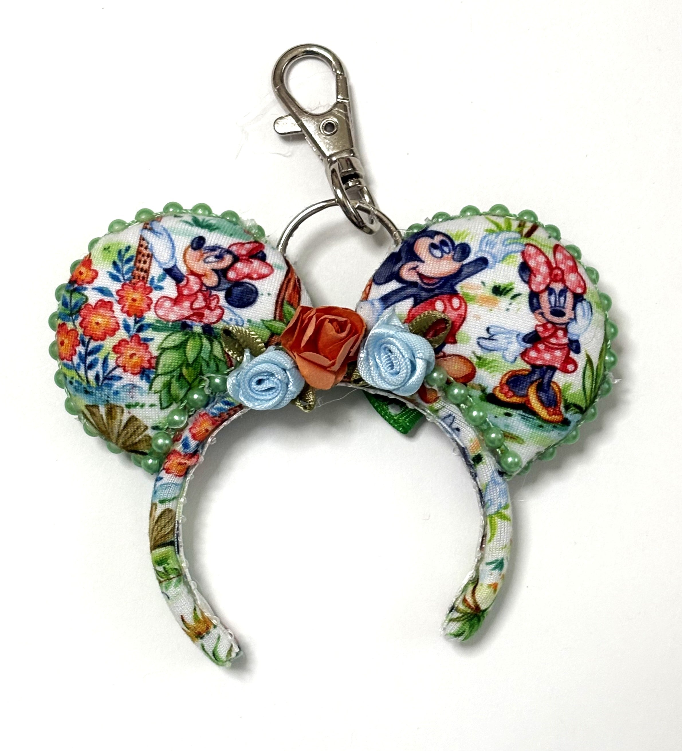 Pixie Park Company Picnic Pals Mini Magic Charm featuring playful picnic-inspired artwork, a coordinating boutique bow, decorative beaded trim, and a silver keyring with lobster clasp attachment.