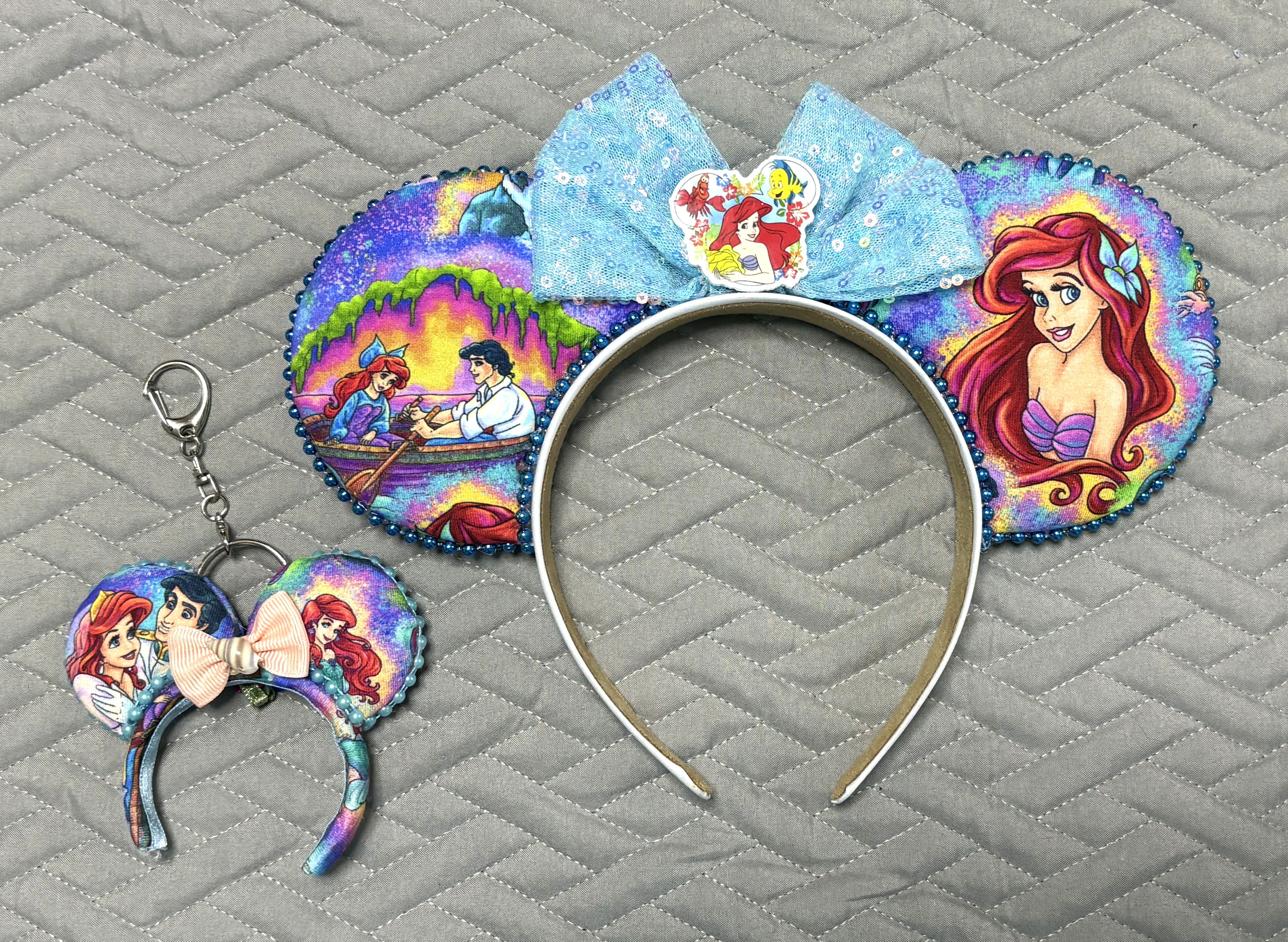 Handcrafted A Mermaid's Wish Pixie Pair featuring a boutique mouse ear headband with a matching Mini Magic Charm in elegant ocean-inspired blue, teal, and shimmering fairytale styling.