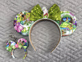 Handcrafted Bayou Blossom Pixie Pair featuring a boutique mouse ear headband with a matching Mini Magic Charm in elegant floral bayou-inspired green and gold styling.
