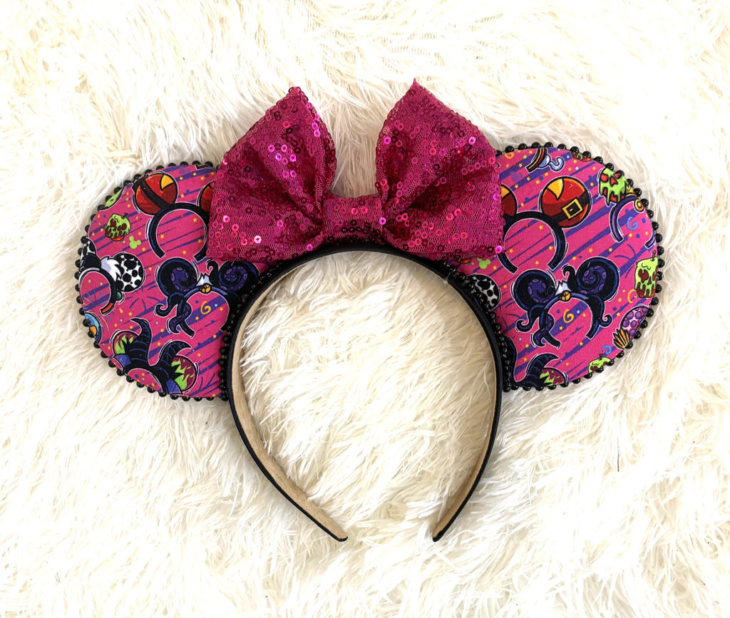 "Handcrafted Halloween mouse ear headband with spooky Halloween print, magenta sequined bow, black beaded trim, and boutique styling for theme park outfits by Pixie Park Co."
