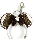 Handcrafted Haunted Couture Mini Magic Charm featuring luxury-inspired ghost-themed fabric, elegant neutral tones, boutique detailing, and a secure clasp for backpacks, purses, keychains, and Halloween park adventures.