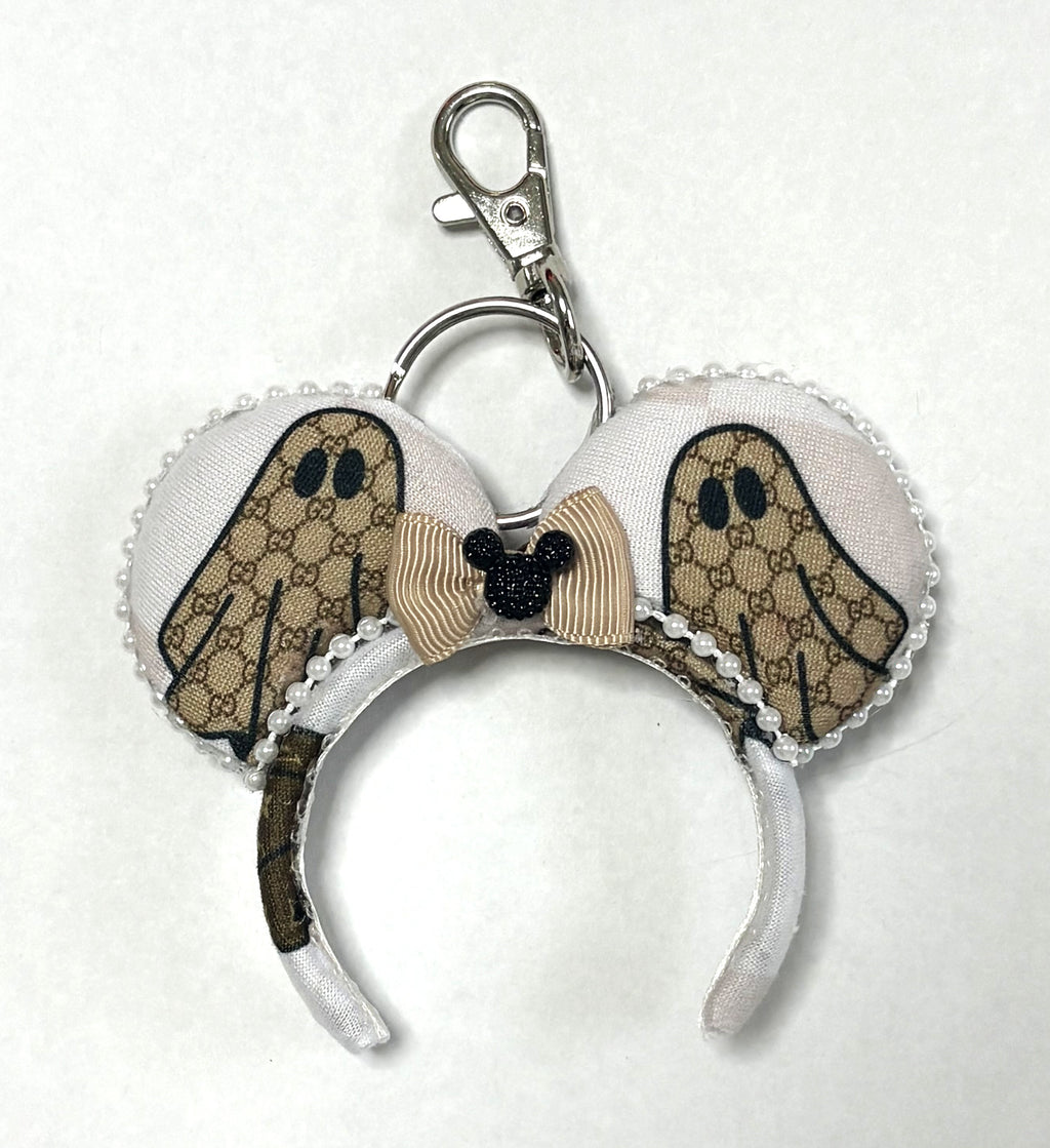 Ghostly Glamor handcrafted mini ear charm featuring neutral ghost-inspired fabric, pearl trim, floral accents, lobster clasp and split ring.