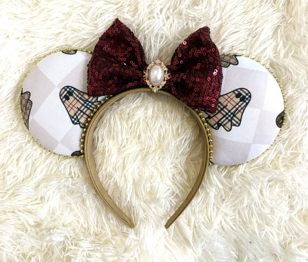 Haunted Elegance handcrafted Halloween mouse ear headband featuring designer-inspired ghost patterns, burgundy sequin bow, gold beaded trim and pearl-style jeweled centerpiece.