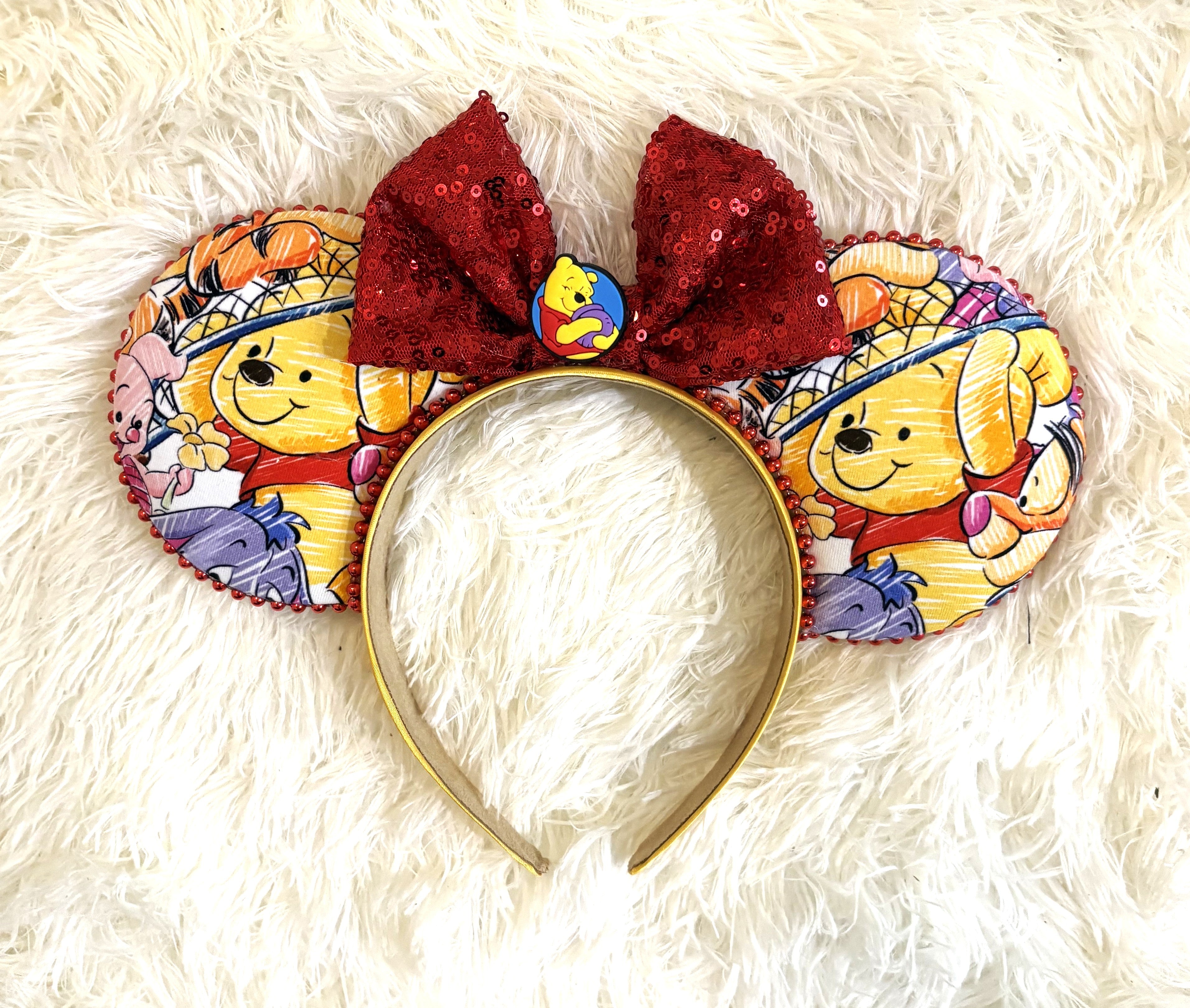 Honey Bear & Friends handcrafted mouse ear headband featuring colorful honey-bear and woodland-friend imagery, red sequin bow and coordinating red beaded trim.