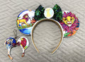 Savanna Royalty Pixie Pair featuring a handcrafted lion and savanna-inspired mouse ear headband with green sequin bow and matching Mini Magic Charm.