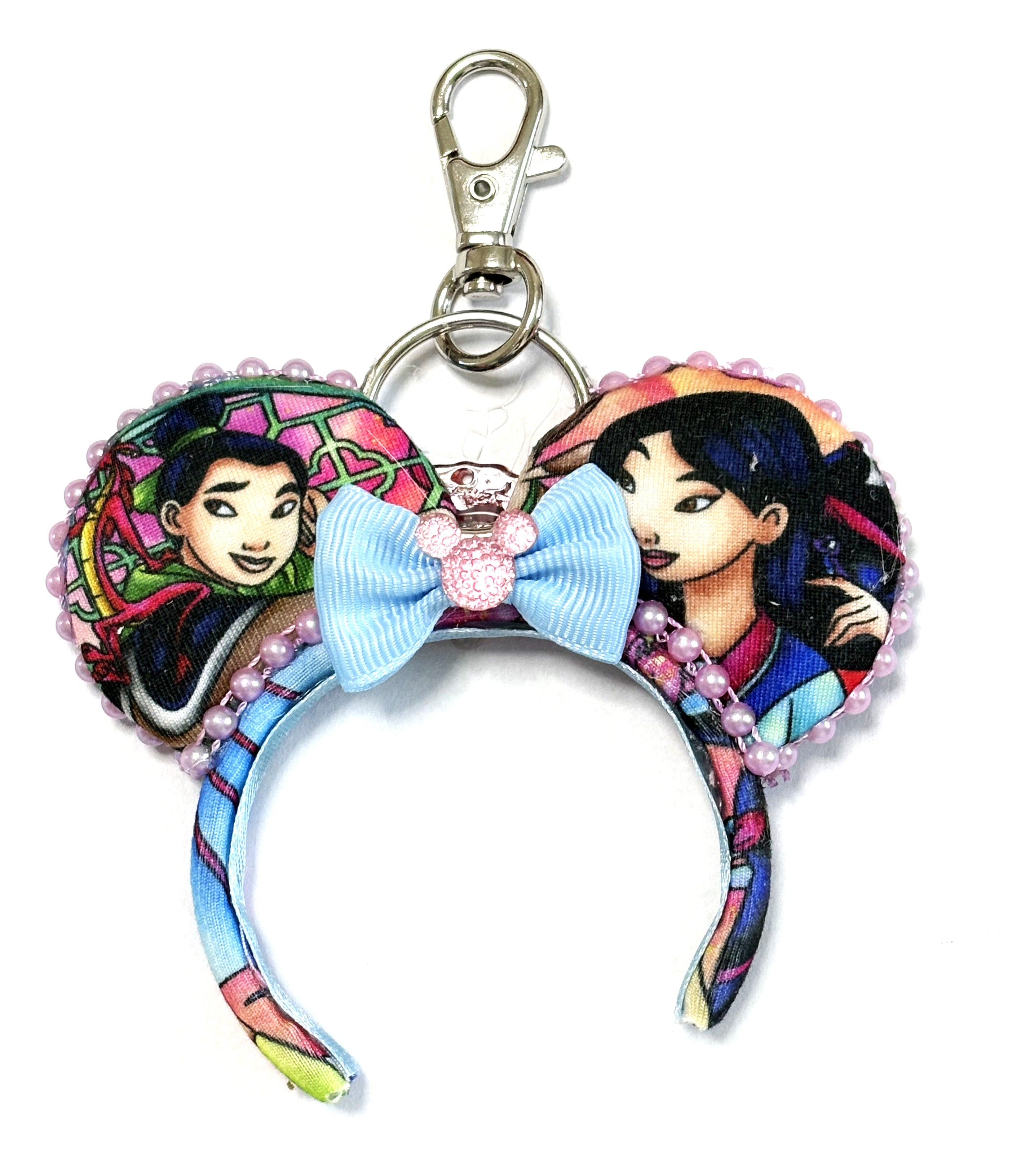 Blossom Warrior handcrafted mini ear charm featuring heroine-inspired imagery, pink blossom details, rich blue accents, coordinating bow, lobster clasp and split ring.