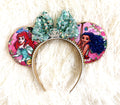 Handcrafted Waves & Wishes Princess Duo mouse ear headband featuring two ocean princess-inspired designs, a seafoam sequined bow, crystal crown centerpiece, pink floral fabric, and gold beaded trim by Pixie Park Co.