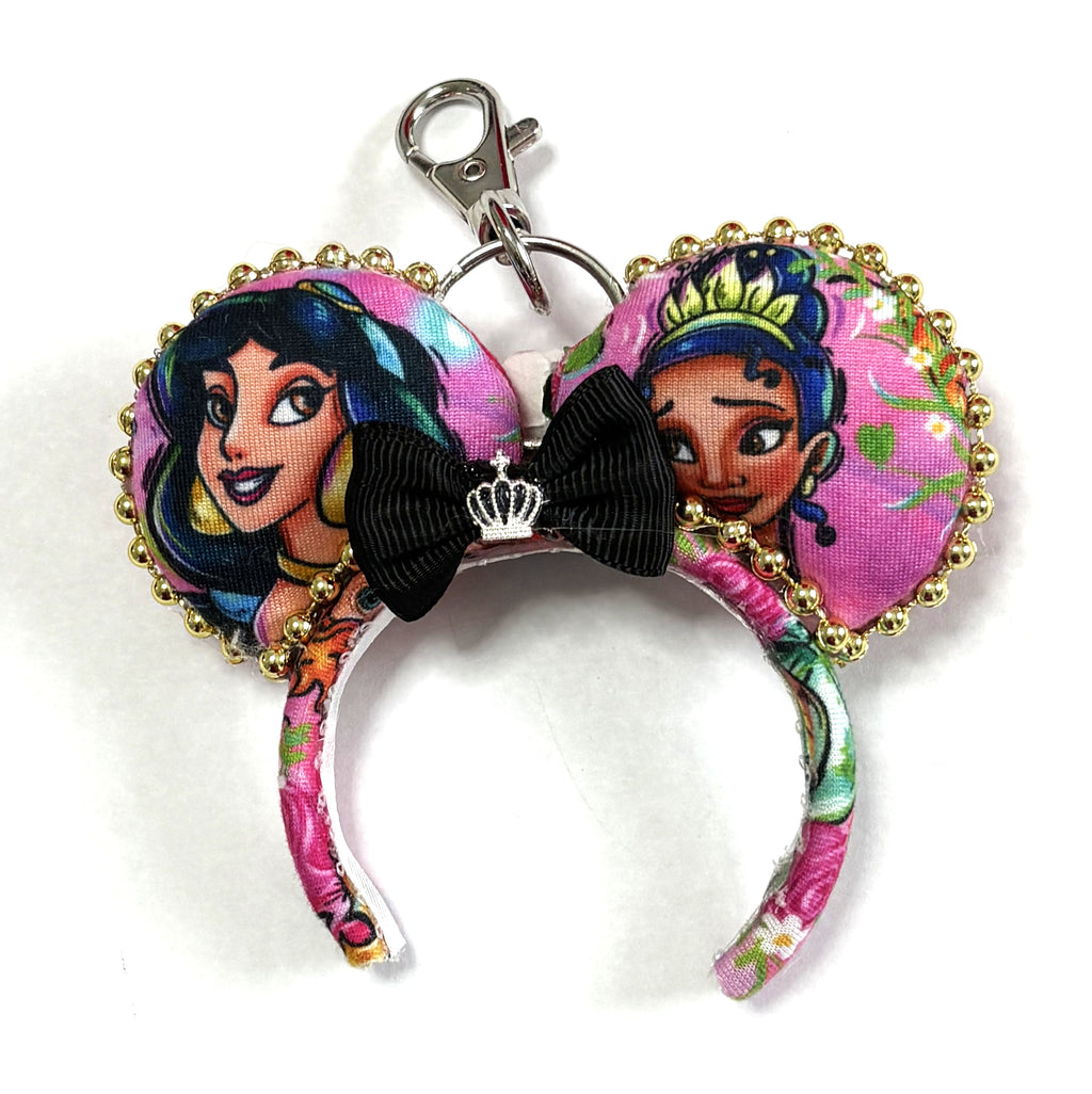 Handcrafted Emerald Wishes Princess Duo Mini Magic Charm featuring two princess-inspired mouse ears, a coordinating bow, pink floral fabric, and sparkling gold trim by Pixie Park Co.