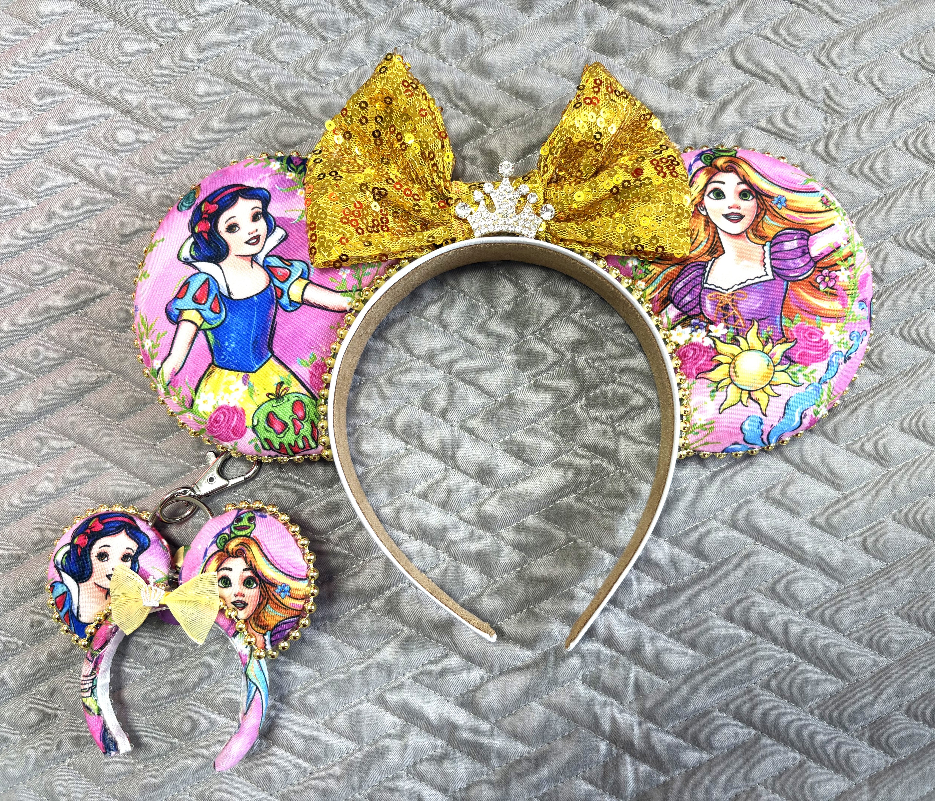 Golden Reflection Princess Duo Pixie Pair featuring a handcrafted fairy-tale princess-inspired mouse ear headband with gold sequined bow and jeweled crown plus a matching Mini Magic Charm by Pixie Park Co.