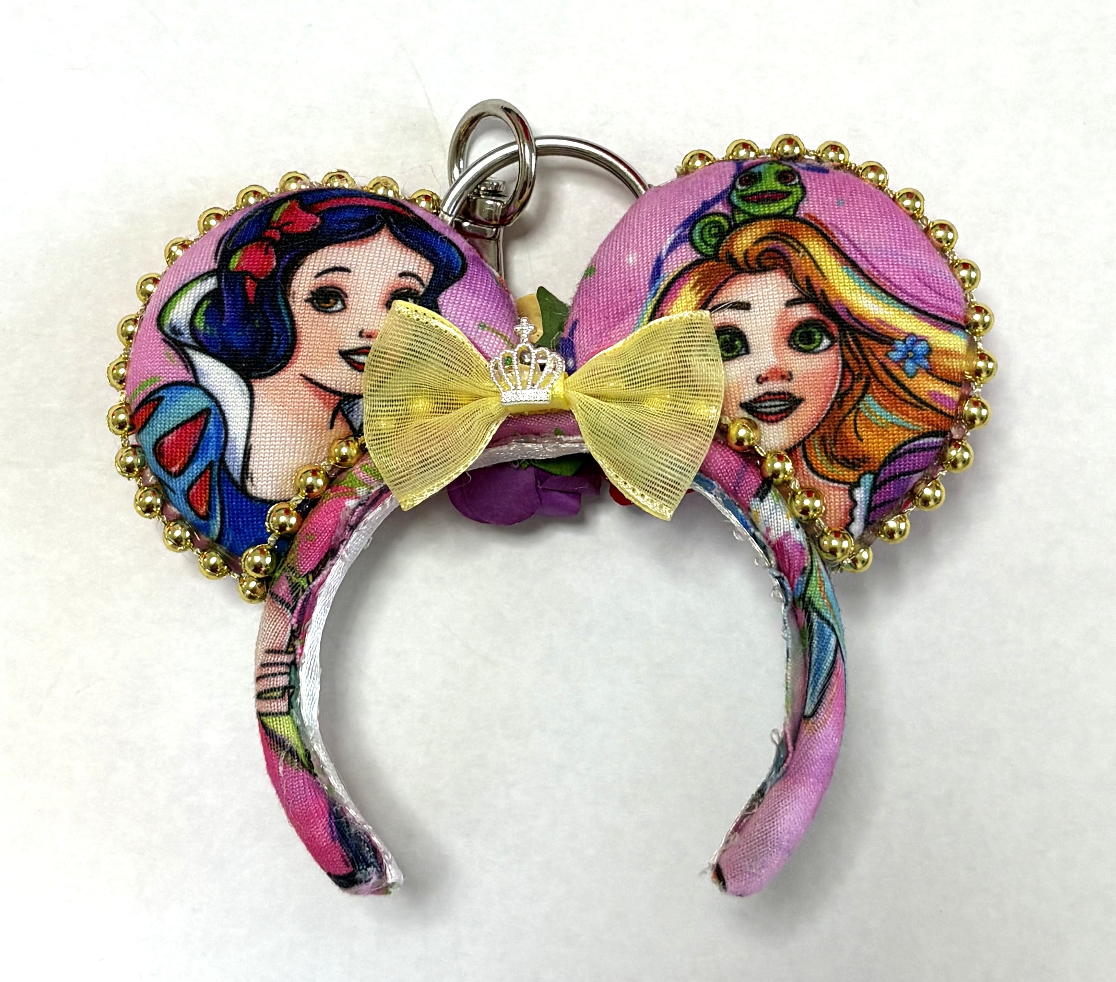 Handcrafted Golden Reflection Princess Duo Mini Magic Charm featuring two fairy-tale princess-inspired mouse ears, a golden bow, pink fabric, and sparkling gold trim by Pixie Park Co.