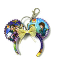 Shop the Golden Tower Mini Magic Charm, a handcrafted princess-inspired bag charm with colorful storybook ears, sparkling trim and delicate bow.