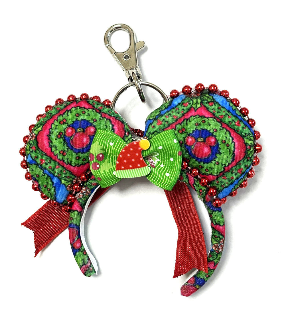 Handcrafted Merry Mousemas Mini Magic Charm with colorful Christmas wreath ears, sparkling red beaded trim, festive green-and-red bow and lobster clasp.