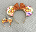 Handcrafted Pumpkin Patch Magic Pixie Pair featuring a matching autumn pumpkin-print Signature mouse ear headband with a sparkling copper-orange sequin bow, gold beaded trim, and coordinating miniature ear keychain and bag charm.