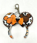 Handcrafted Harvest Mouse Magic mini ear keychain and bag charm featuring colorful autumn mouse silhouettes, copper-brown beaded trim, a golden-orange bow with a sparkling black centerpiece, and a metal clasp.