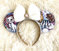 Handcrafted Parisian Kitty mouse ear headband with colorful kitten print, white pearl-beaded trim, plush white faux-fur bow and ornate pearl-inspired jewel centerpiece.