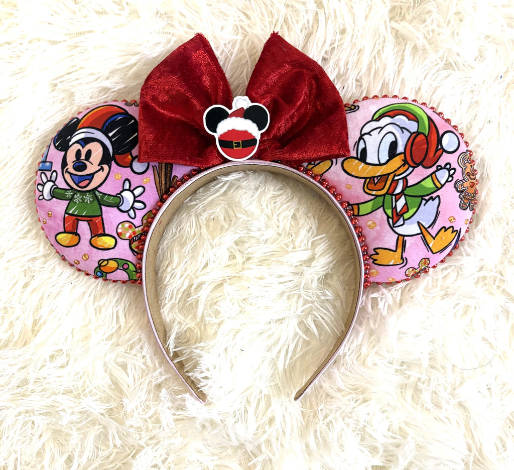 Jolly Holiday Friends handcrafted mouse ear headband featuring pink Christmas character fabric, ruby-red beaded trim, oversized red velvet bow, and Santa-inspired centerpiece.